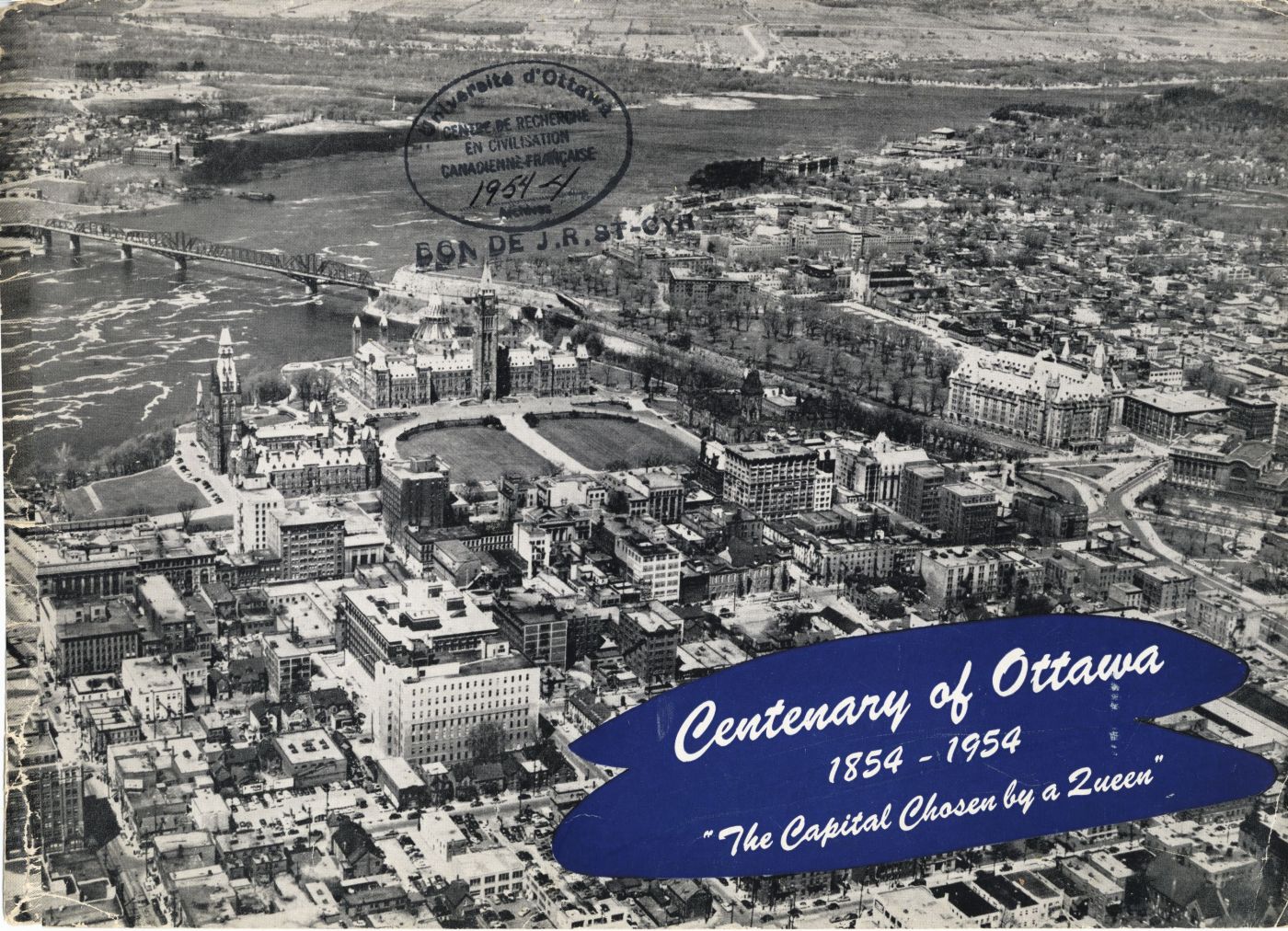 Photographie en noir et blanc qui montre une vue aérienne rapprochée du centre-ville d’Ottawa avec, au centre, les édifices du Parlement. Texte dactylographié en anglais.